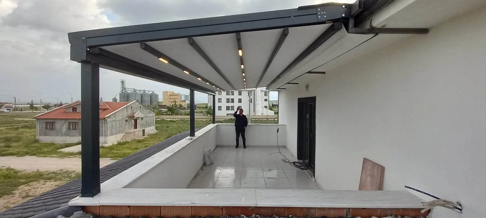 Çatı katı terasında güneş alan cepheyi gölgeleyen pergola sistemi